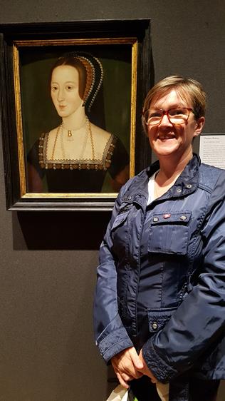 Claire Ridgway standing next to the NPG portrait of Anne Boleyn
